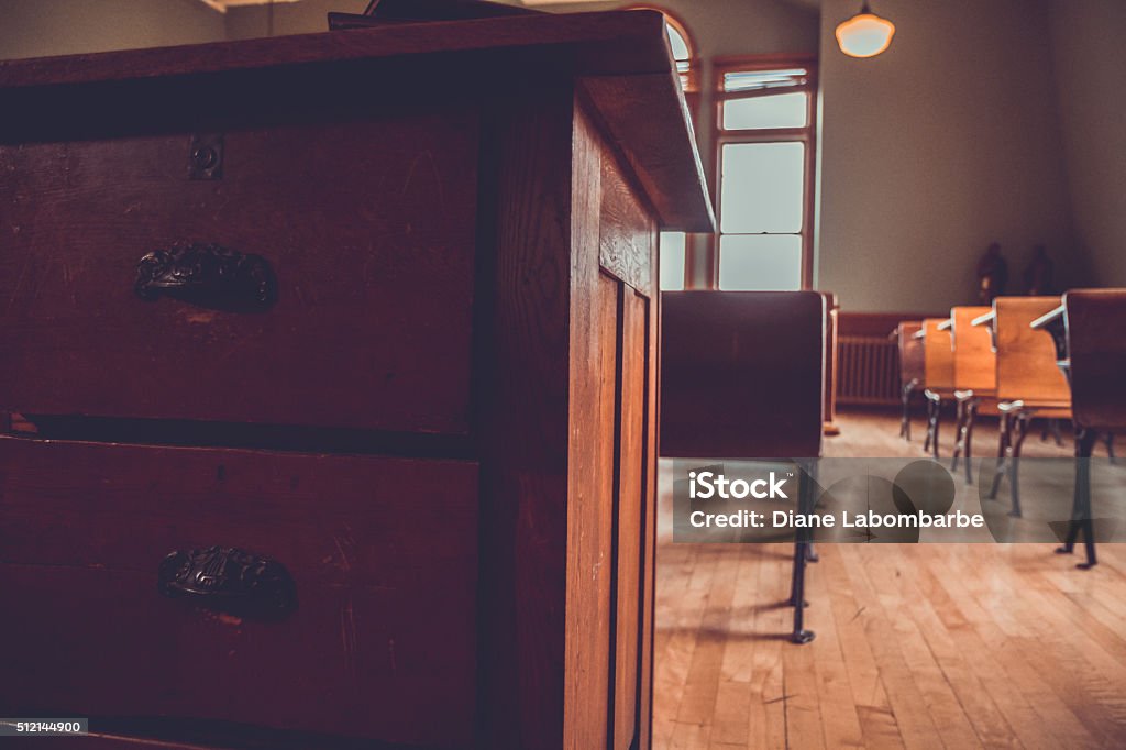 Rows of Vintage Student Desks in An Old Schoolhouse Vintage Student Desks. Rows of old wood and steel school desks in an old historic classroom. There is an old wood floor beneath. Antique Stock Photo