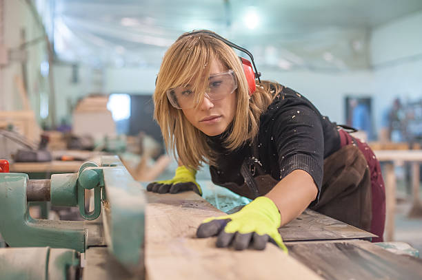 weibliche tischler mit elektrischer sander - rohstoffverarbeitende fabrik stock-fotos und bilder