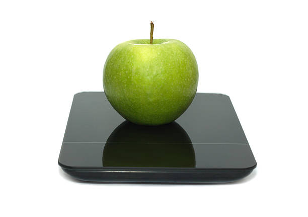 Green apple and tape measure on Bathroom scale