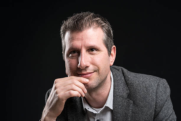 istock attractive businessman portrait smiling and daydreaming 512149788