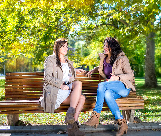 istock Two female friends talking in a park 512151245
