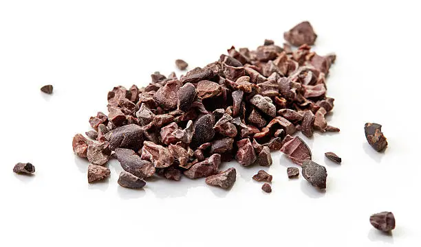 Photo of Heap of cacao nibs on white background