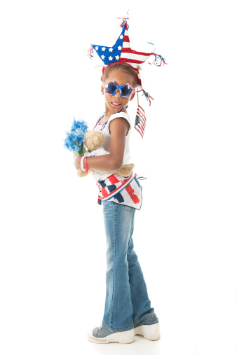 Full-length image of a young elementary girl dressed to display herAmerican  patriotism.  On a white background.