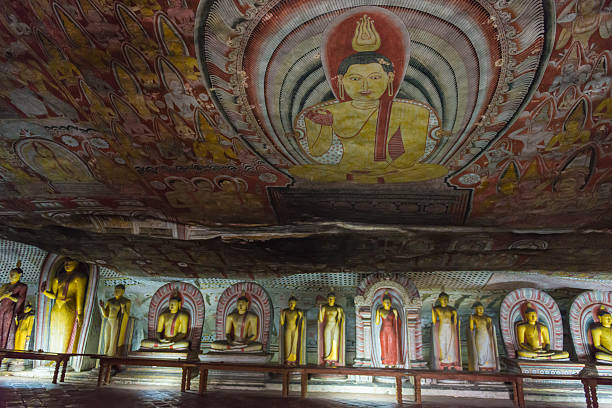 Statues of Buddha in Dambulla Golden Temple in Sri Lanka Statues of Buddha in line in Temple house in the caves known as Dambulla royal cave Temple or Golden Temple, which is one of UNESCO World Heritage sites in Sri Lanka. There are around 153 statues of Buddha representing everyday life, some statues of kings and Hindu gods. The ceiling has picturesque paintings as well. dambulla stock pictures, royalty-free photos & images