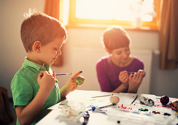 istock Brother and sister painting easter eggs 512152708