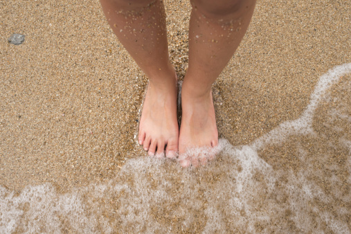 Many footprints on sandy beach background.
