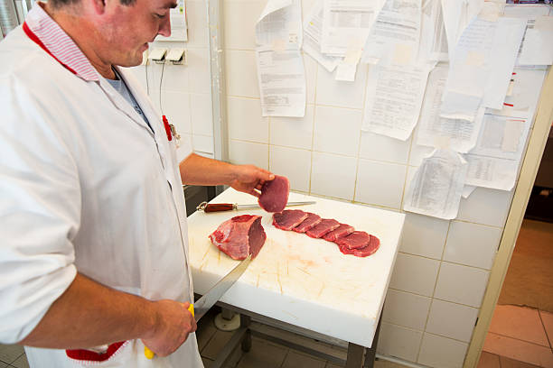 istock Butchery...Butcher is cutting pork chops 512154139