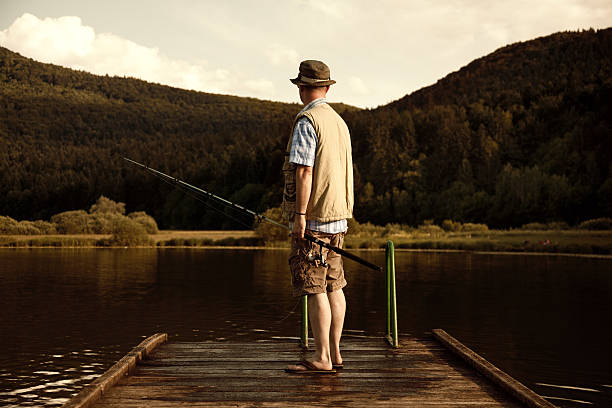 sport fisherman going to fishing on lake pier