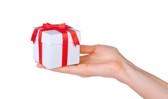 Box with a gift in the hand of woman isolated on white background.