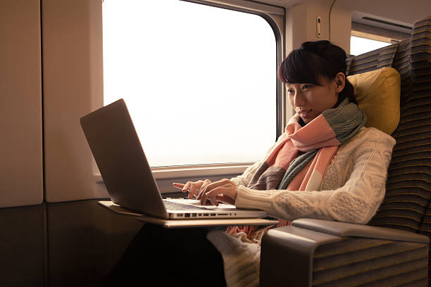 Young woman using her  computer while traveling by train stock photo
