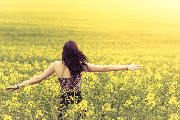 istock Beautiful genuine woman in sunny summer meadow from behind left 512156344