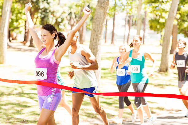 istock Smiling Female Marathon Runner Crossing Finish Line 512156921