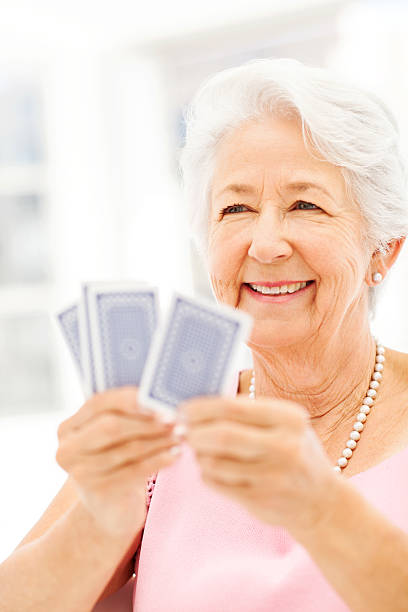 istock Senior Woman Smiling While Playing Cards 512156931