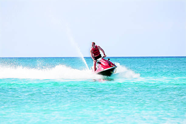 istock Young guy cruising on a jet ski on caribbean sea 512157368