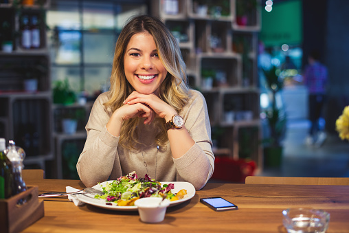 Attractive woman enjoying healthy food in a restaurant.