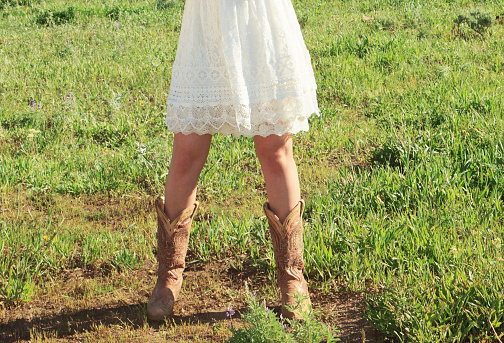Cute Cowgirl Boots and Lace Dress. the image is cropped at the waist
