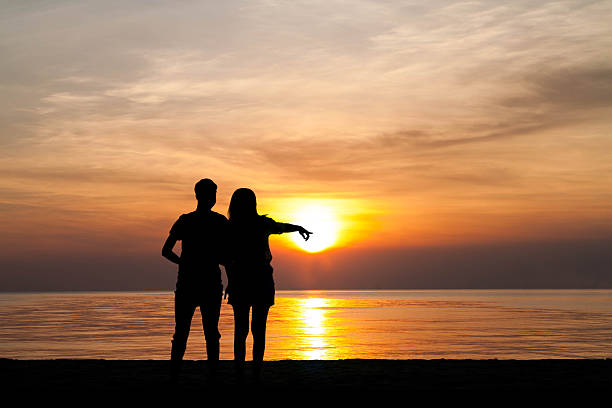 istock two people in love at sunset 512160588