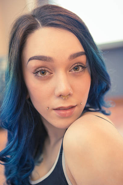 tattooed young womanwith blue hair tattooed young woman with bleu hair exercising in gym.  septum piercing stock pictures, royalty-free photos & images