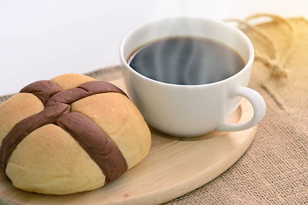 istock Bread and hot coffee on wooden coaster, focused on cup. 512163306