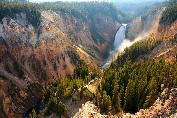 Sunlight illuminates the spray as the Yellowstone River crashes over the Lower Falls in Yellowstone's Grand Canyon.