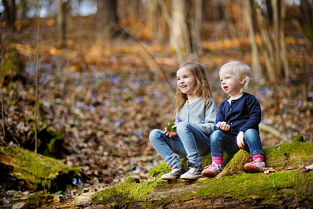 istock Two sisters picking the first flowers of spring 512164846