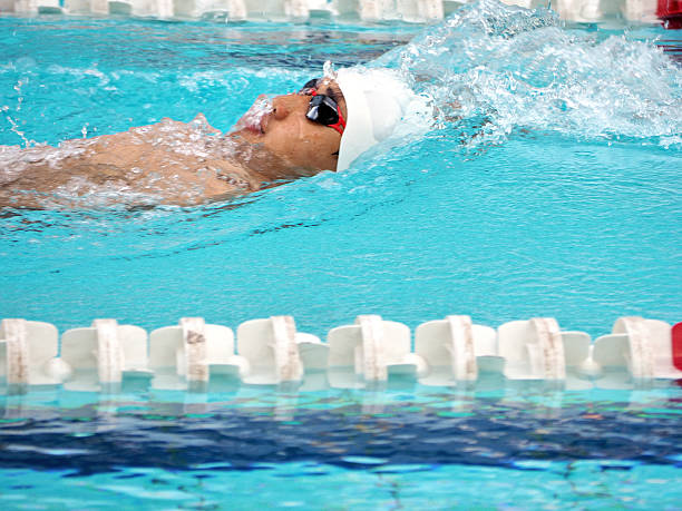 An Asian man with amputated left arm due to accident is swimming joyfully at the pool.