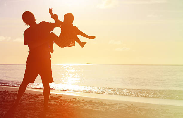 istock father and little son silhouettes play at sunset 512171046