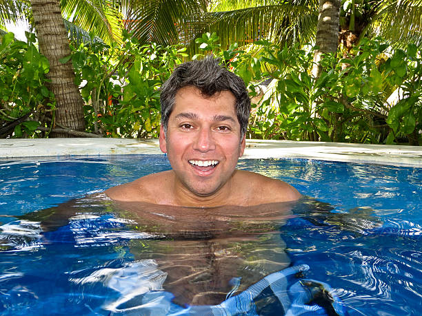 Man in a hot tub Young man relaxing in a hot tub in the tropics trishz stock pictures, royalty-free photos & images