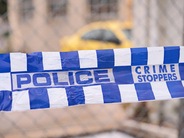 Police tape cordoning off a area with a yellow car