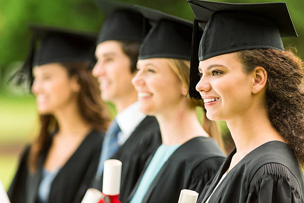 istock Girl Wearing Gown And Mortar Board With Students On Campus 512173311