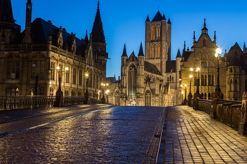 A view towards Saint Nicholas' Church in Ghent City Center at dusk in the morning. A cobbled road can be seen leading towards the landmark.