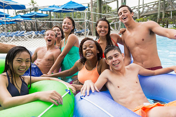 multirracial grupo de adolescentes en el parque acuático - floating on water swimming pool men water fotografías e imágenes de stock