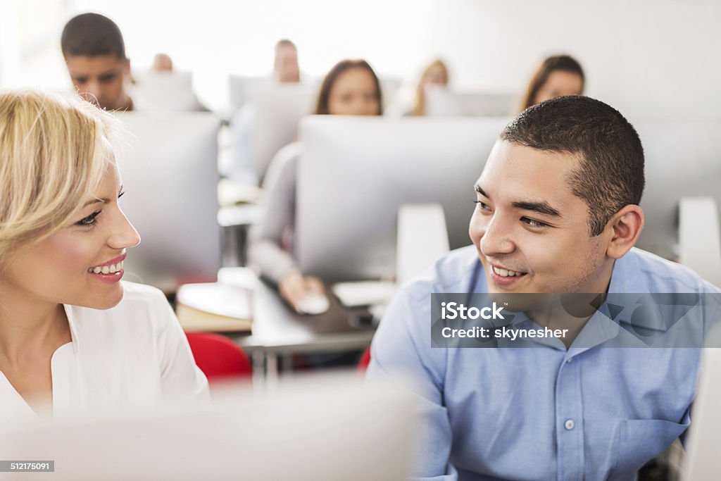 Business people at a computer class. Businesswoman communicating with her Asian colleague at computer class.   30-39 Years Stock Photo