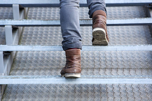 istock Man walking up stairs in boots 512175225