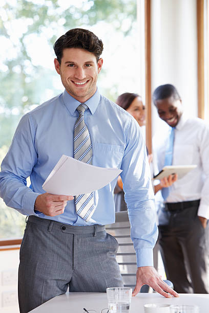 istock Businessman Standing In Boardroom Holding Document 512185397