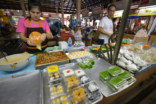 Bangkok, Thailand - March 25, 2014: Woman making candy in a market in Bangkok, Thailand