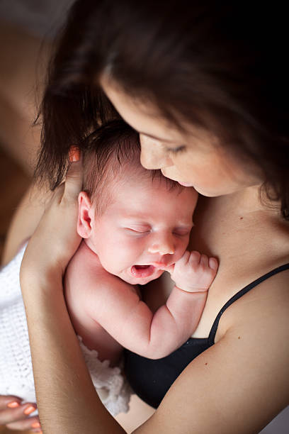 Young mother and her sleeping baby stock photo