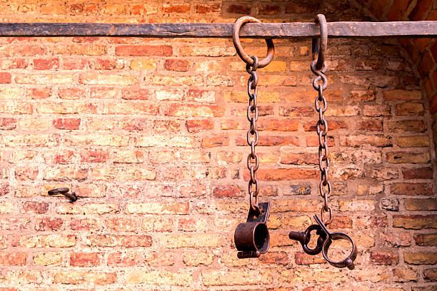 prison chains Middle aged prisoners chains and cuffs over a brick wall torture photos stock pictures, royalty-free photos & images