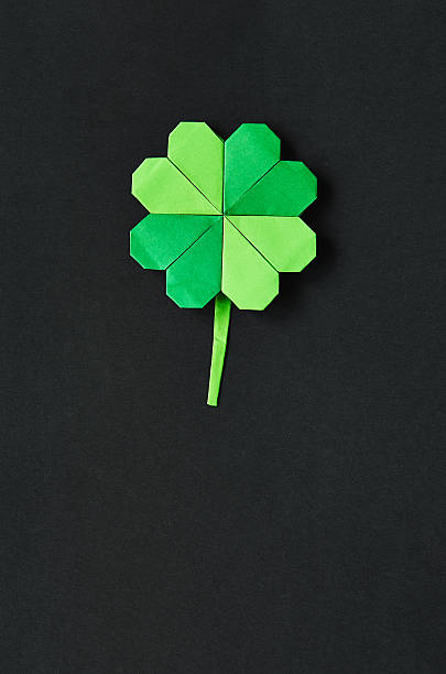 istock Green origami shamrock clover leaf paper background 512211220