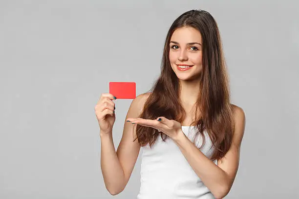 Photo of Smiling woman showing blank credit card in white t-shirt, isolated