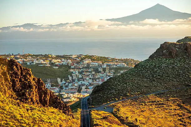 Landscape view on mountain road and San Sebastian city with Tenerife island on the background in the morning