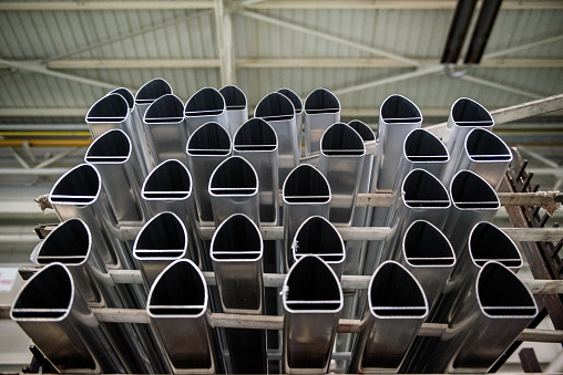 Large group of aluminium poles in factory, low angle view