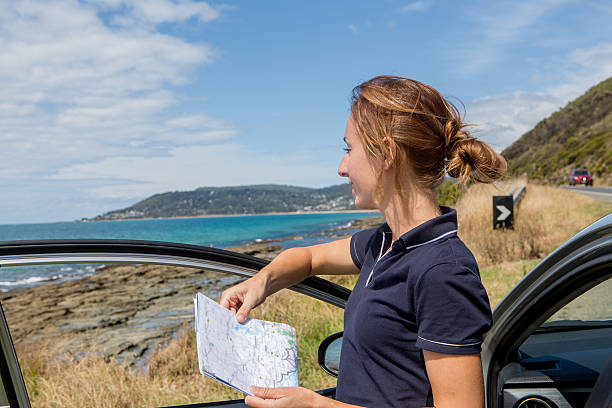istock Young woman looks at road map 512215536