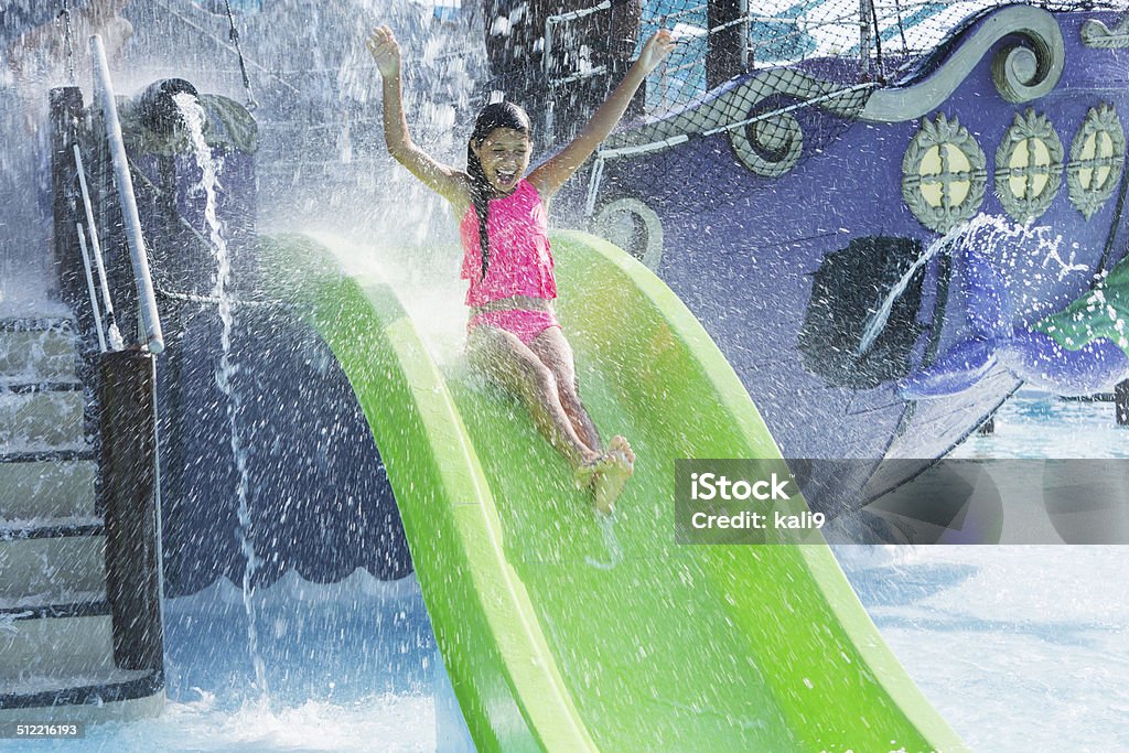 Girl on water slide Girl at water park, going down water slide.  12 years, mixed race Caucasian / Pacific Islander. Slide - Play Equipment Stock Photo