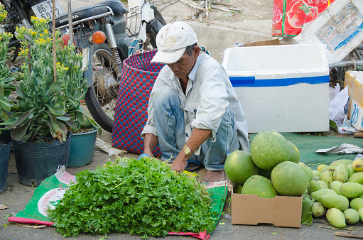 Phan Thiet, Vietnam - February 6, 2016: Unidentified street vendor at Phan Thiet market. Vietnam