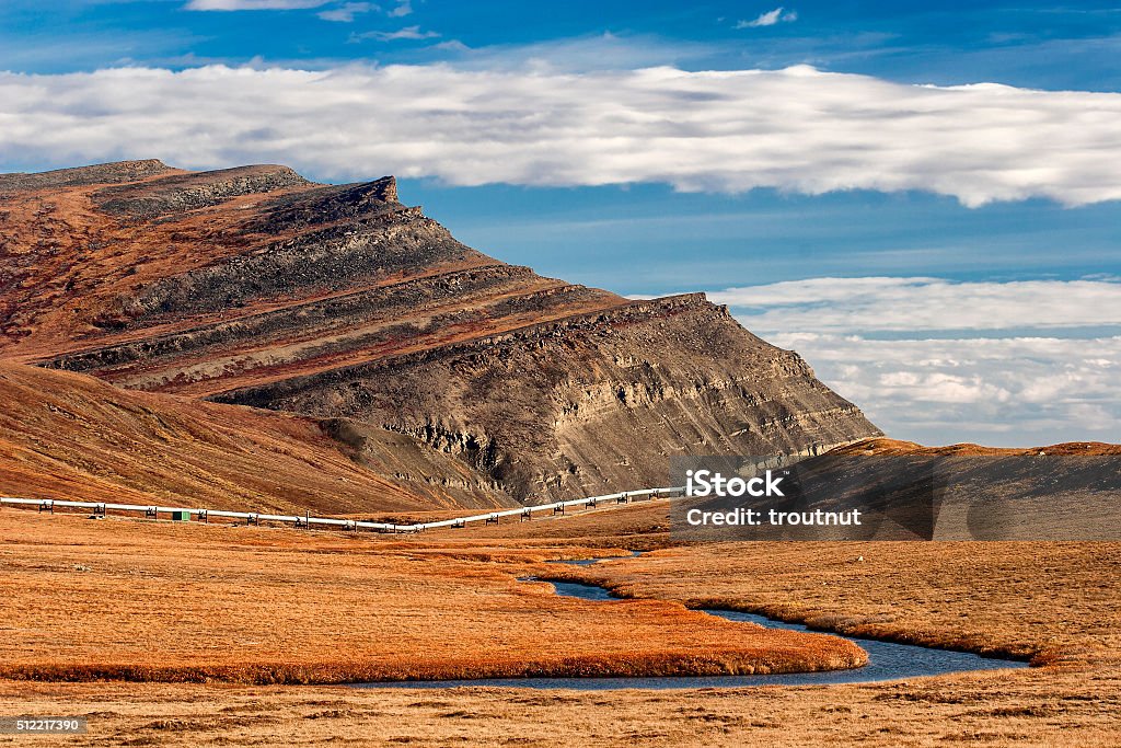 Slope Mountain and the Alaska Pipeline Oksrukuyik Creek winds along the Alaska Pipeline beneath the distinctive landmark Slope Mountian on Alaska's North Slope Dalton Highway Stock Photo