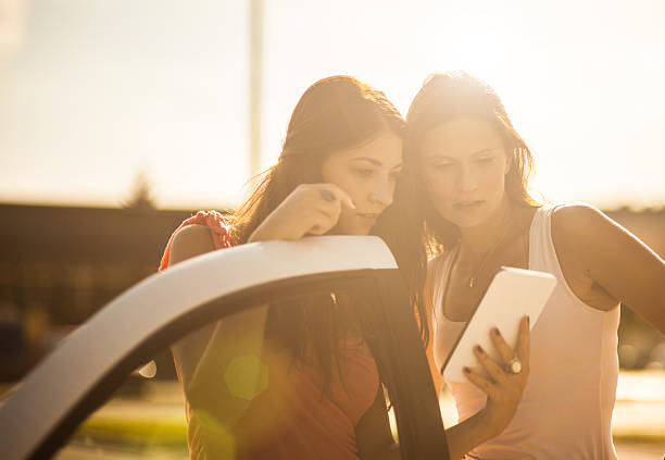 istock Teenage friends using digital tablet by the car 512217479