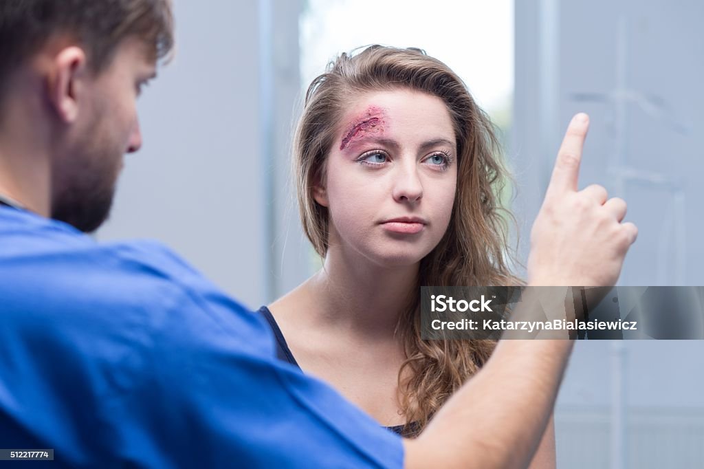 Doctor diagnosing injured woman Picture of male doctor diagnosing injured woman Physical Injury Stock Photo