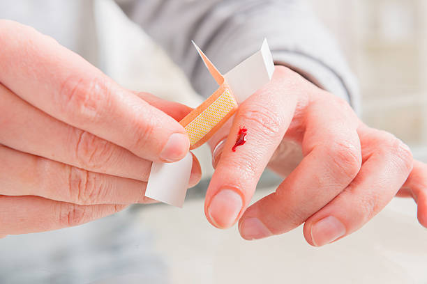 Applying adhesive bandage on finger stock photo