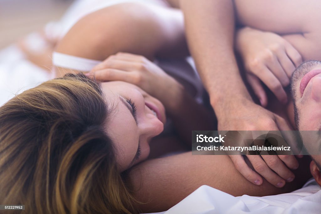 Close-up of woman Close-up of happy young woman in bed with boyfriend Embracing Stock Photo